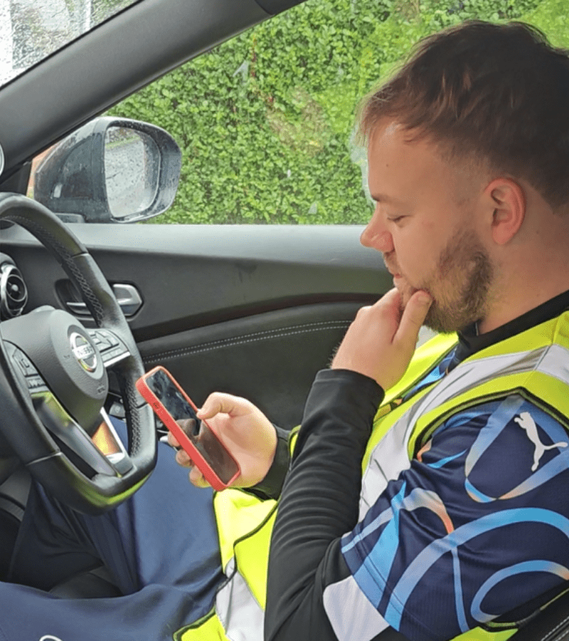  A construction worker using a mobile device for an invigilator online test, demonstrating the accessibility of online exam invigilation software.